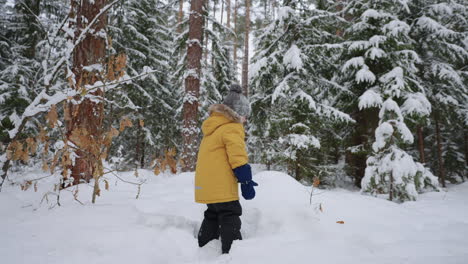 carefree-toddler-is-playing-with-snow-in-forest-in-winter-weekend-happy-and-joyful-little-child
